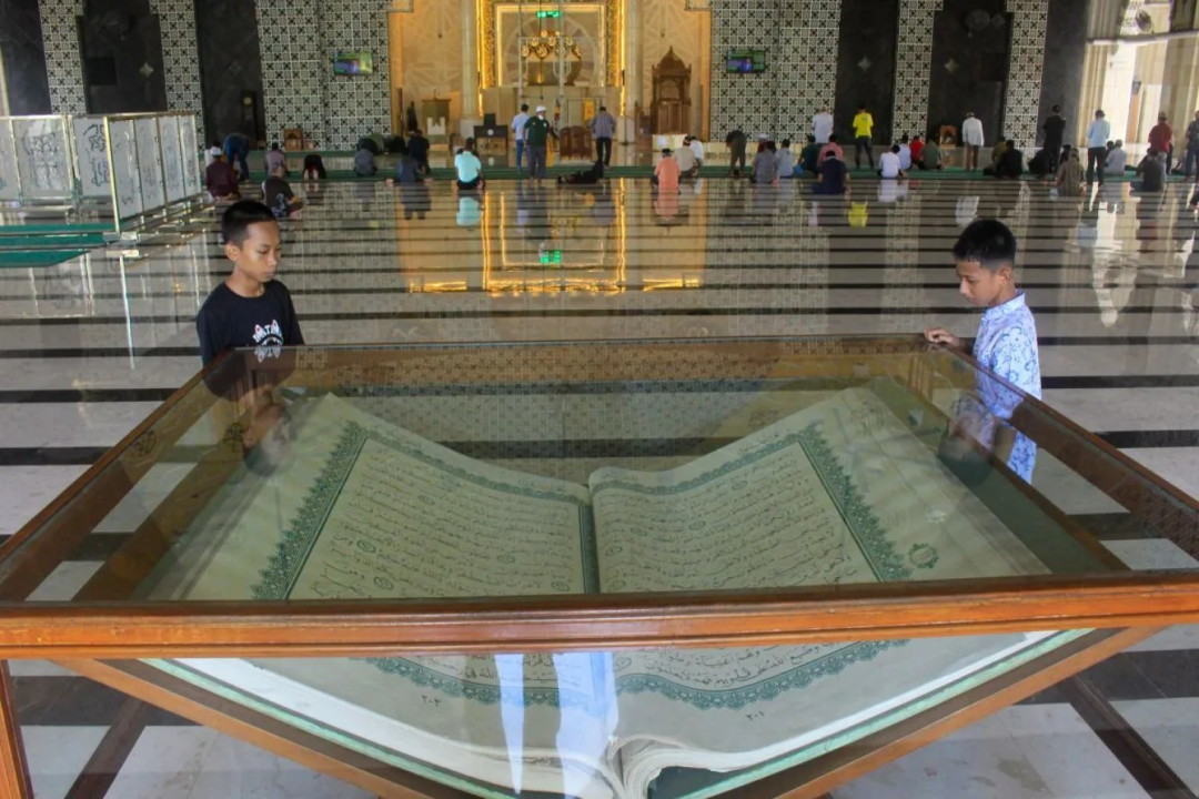Al Quran Raksasa di Masjid Raya Makassar: Keajaiban Tinta Tangan yang Menarik Perhatian Wisatawan